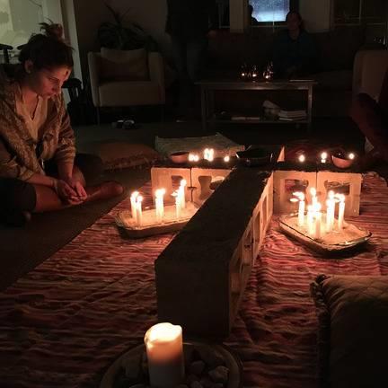 Woman worshiping in front of candles